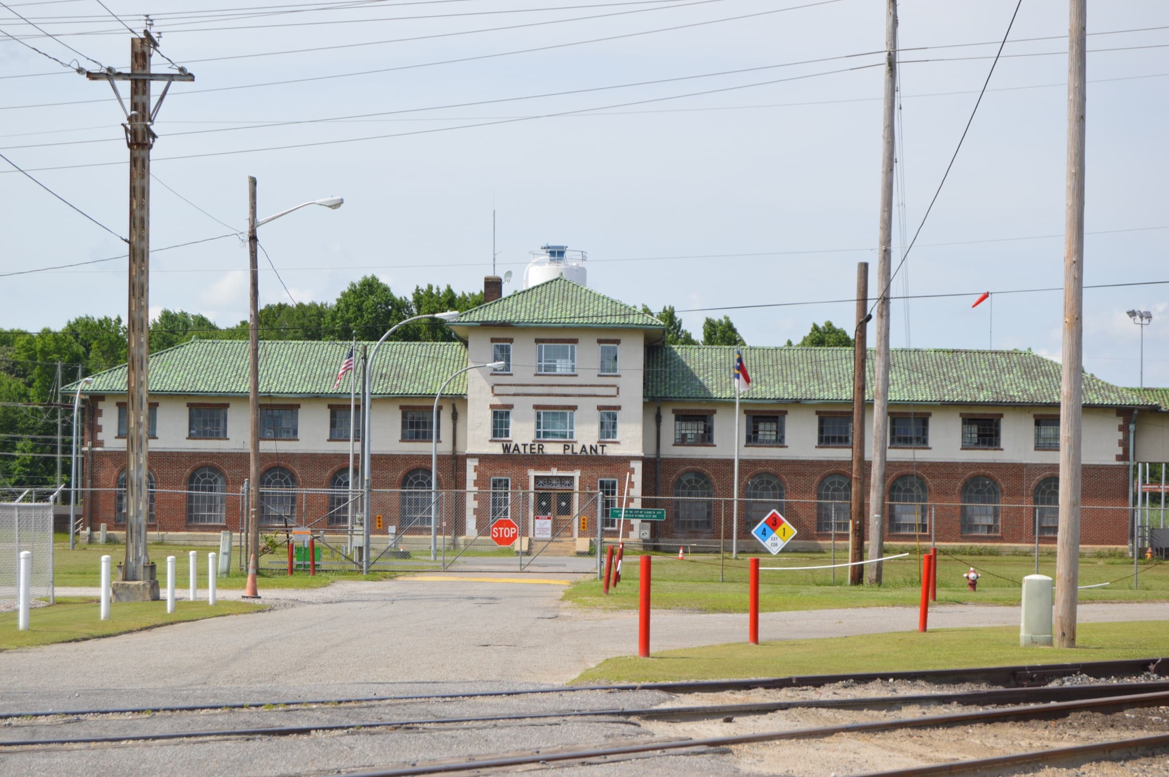 The Elizabeth City Water Plant — a 1926 Mission Revival municipal water building with green-tile roof, brick arches, and 'WATER PLANT' lettered above the entrance, sitting in Coastal Infrastructure's actual North Carolina service territory.